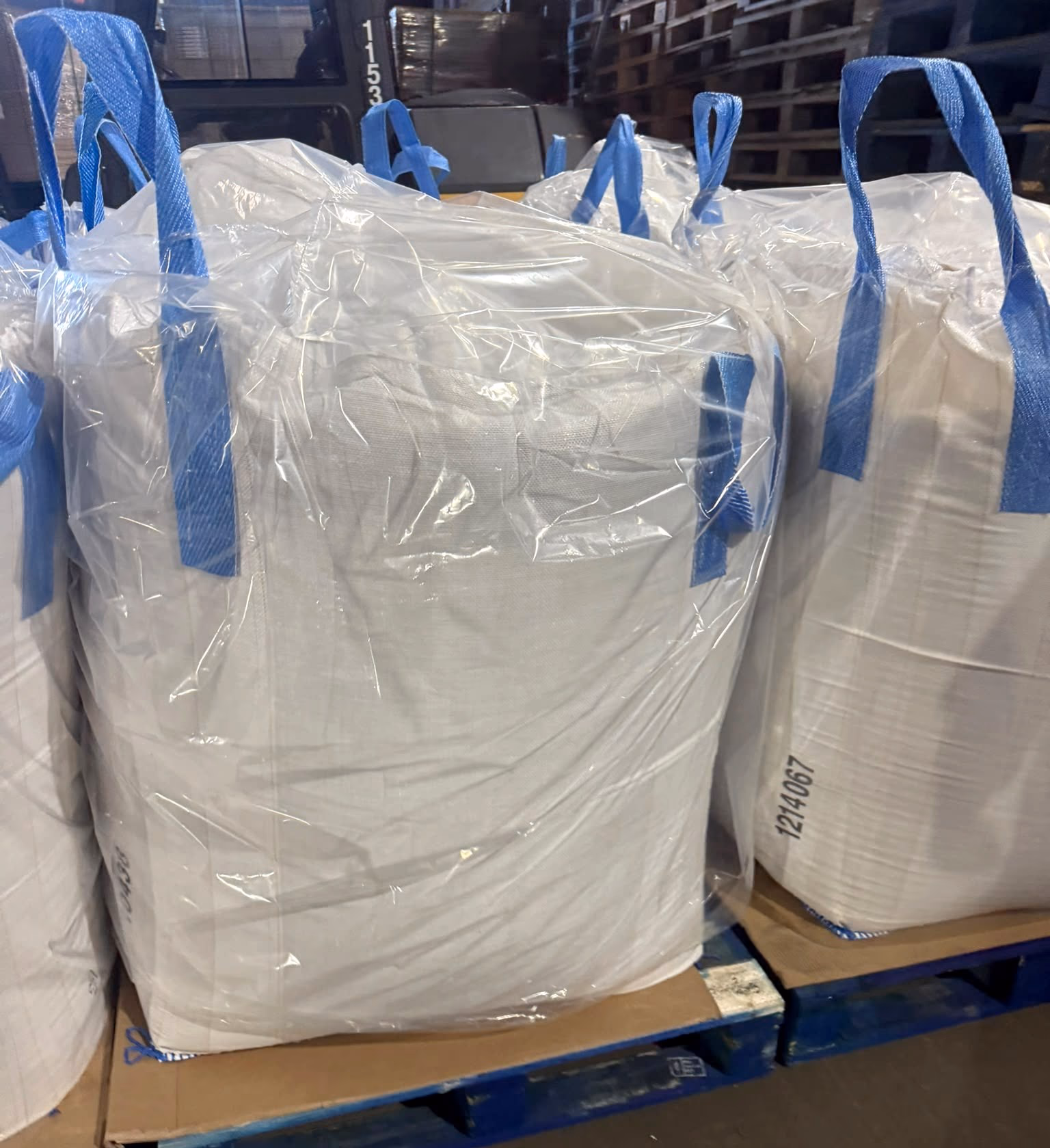 Bulk bags with blue lifting loops stored on pallets