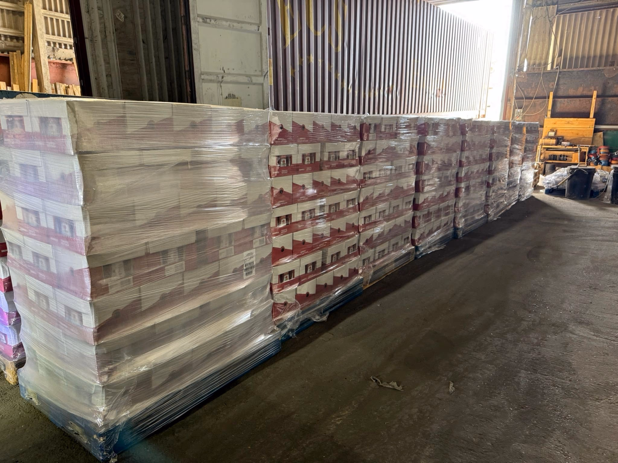 A long row of wrapped full pallets stored inside the MLK warehouse