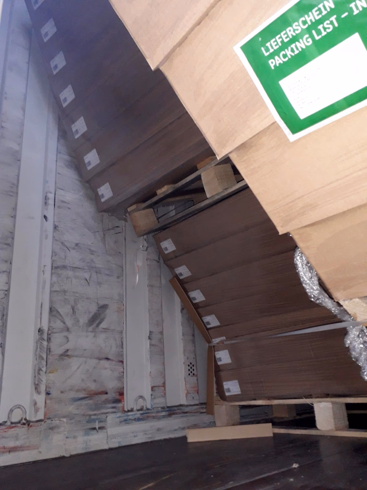 Boxed goods collapsed and leaning against the side of a trailer after shifting in transit