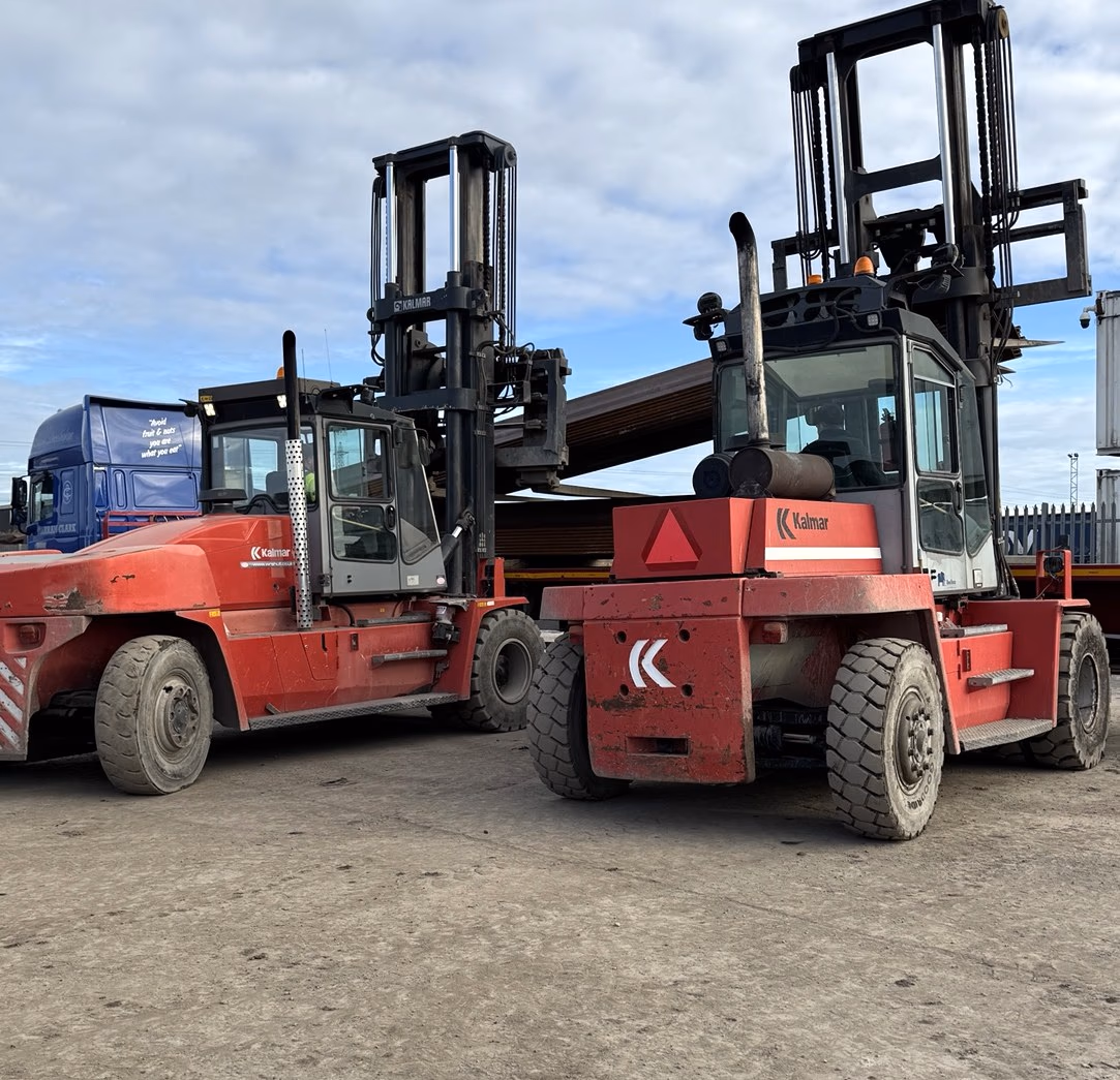 Two red Kalmar heavy-duty forklifts parked side by side in the MLK yard