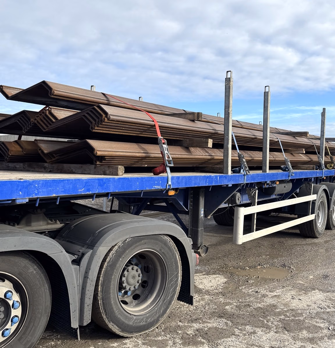 Steel sheet piles strapped to a flatbed trailer ready for collection